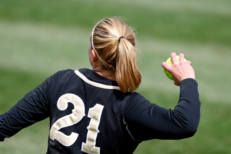 A female athlete throwing a softball