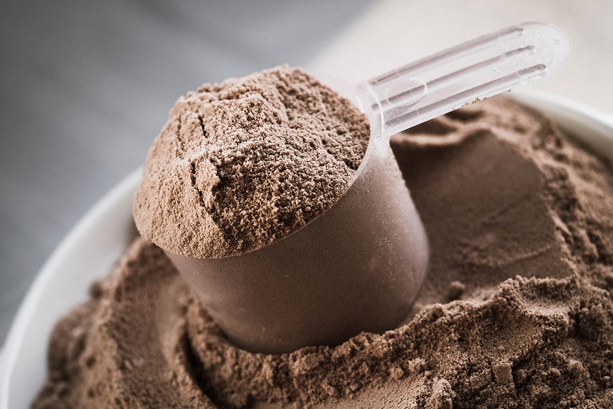A scoop of chocolate flavored protein powder